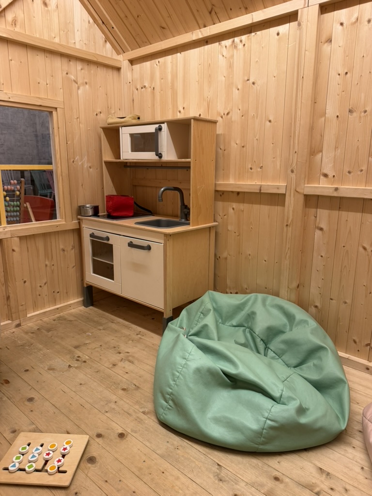 Children’s table with mushroom stools and wooden toys in the play area at Charlie