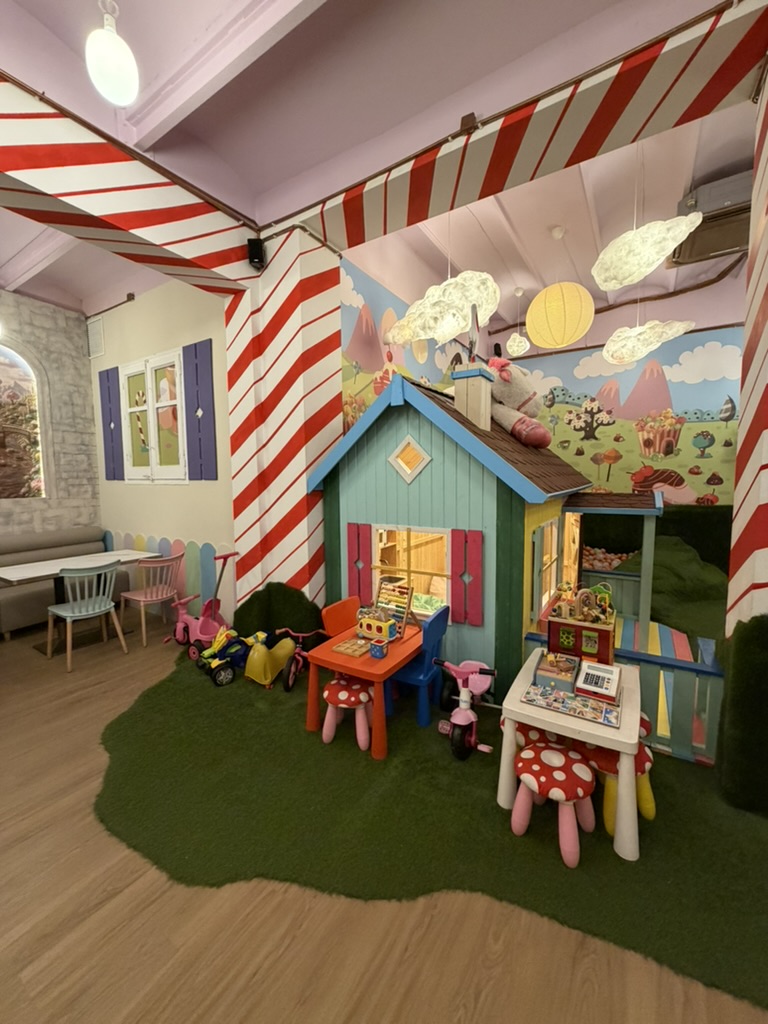 Play corner at Charlie Restaurant, with a little house, mushroom stools and toys